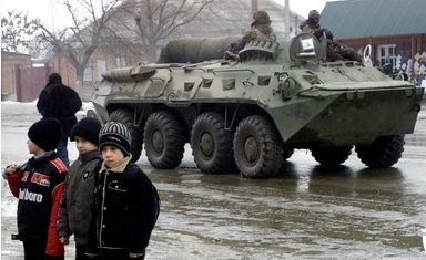 アルグンで、装甲兵員輸送車（APC）のそばを歩くチェチェンの子どもたち